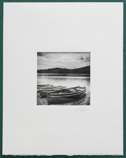 Foto montada. Botes de madera en orilla de lago